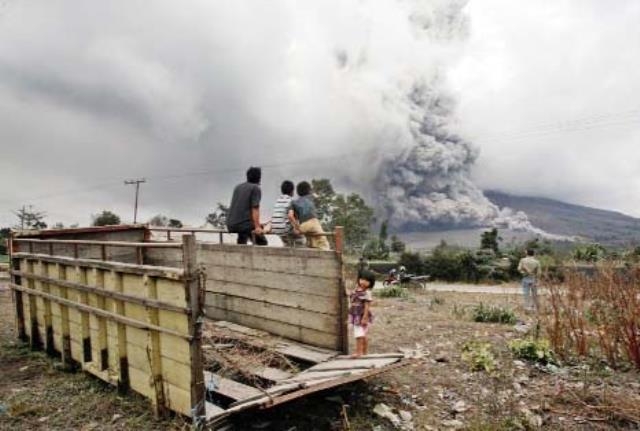 Villagers watch as Mount Sinabung releases pyroclastic flow during an eruption in Beras Tepu, North Sumatra, Indonesia on Saturday.