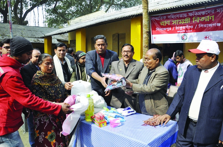 DINAJPUR: Bangladesh Red Cricent Society, Dinajpur District Unit distributing relief goods among the victims of Kornai village recently.