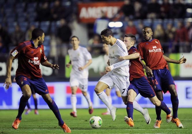 Real Madrid's Cristiano Ronaldo of Portugal (center) duels for the ball with Osasuna's Oier Sanjurjo (second right) during their Spanish Copa del Rey round-16 second leg soccer match at El Sadar stadium in Pamplona, northern Spain on Wednesday.
