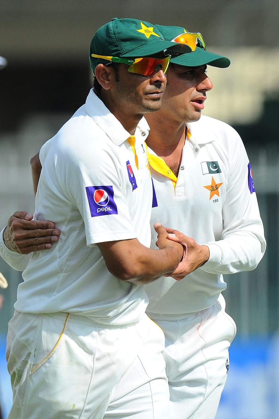 Pakistani bowlers Abdur Rehman (L) and Saeed Ajmal leave the pitch at the end of Sri Lanka's second innings during the final day of the third and final cricket Test match between Pakistan and Sri Lanka at the Sharjah International Cricket Stadium in the