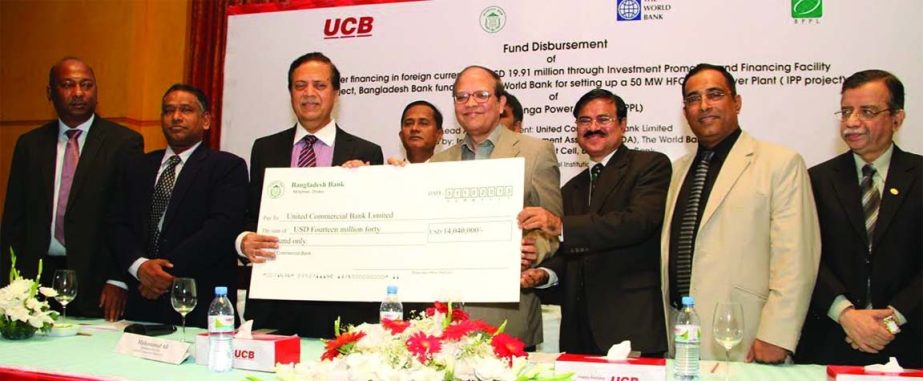 Governor of Bangladesh Bank Dr Atiur Rahman handing over a cheque to Muhammed Ali, Managing Director of United Commercial Bank Limited at a local hotel on Tuesday. A fund created for financing 50 MW Independent power generation plant, "Baraka Patenga Po