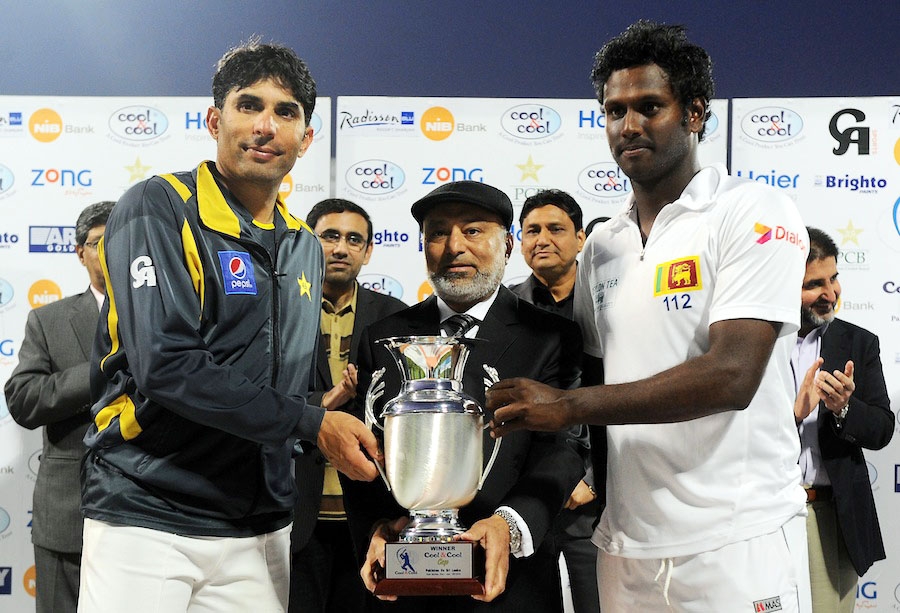 Sri Lankan cricket team captain Angelo Mathews (R) and Pakistan's captain Misbah-ul-Haq (L) holds the series' trophy at the Sharjah International Cricket Stadium during the final day of their third and final cricket Test match at the Sharjah Internation