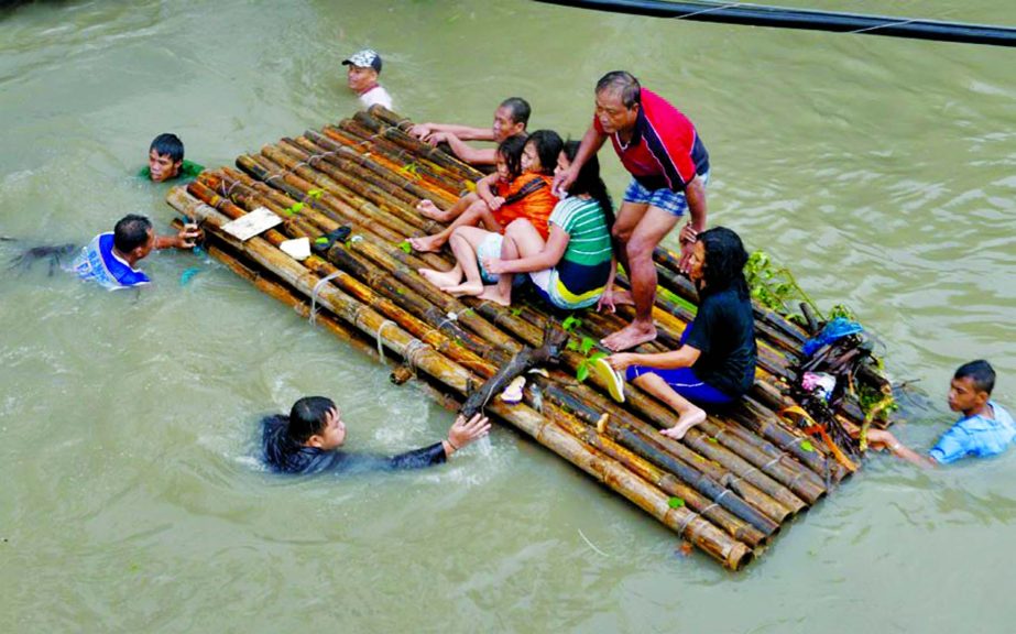 A man is rescued from flood water to a makeshift raft in Butuan in the southern Philippine island of Mindanao. Many hundreds are still stranded on their roofs in the flood-hit area.