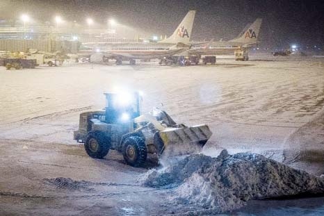 Crew work to remove the snow from the tarmac at Reagan National Airport in Washington on Tuesday .