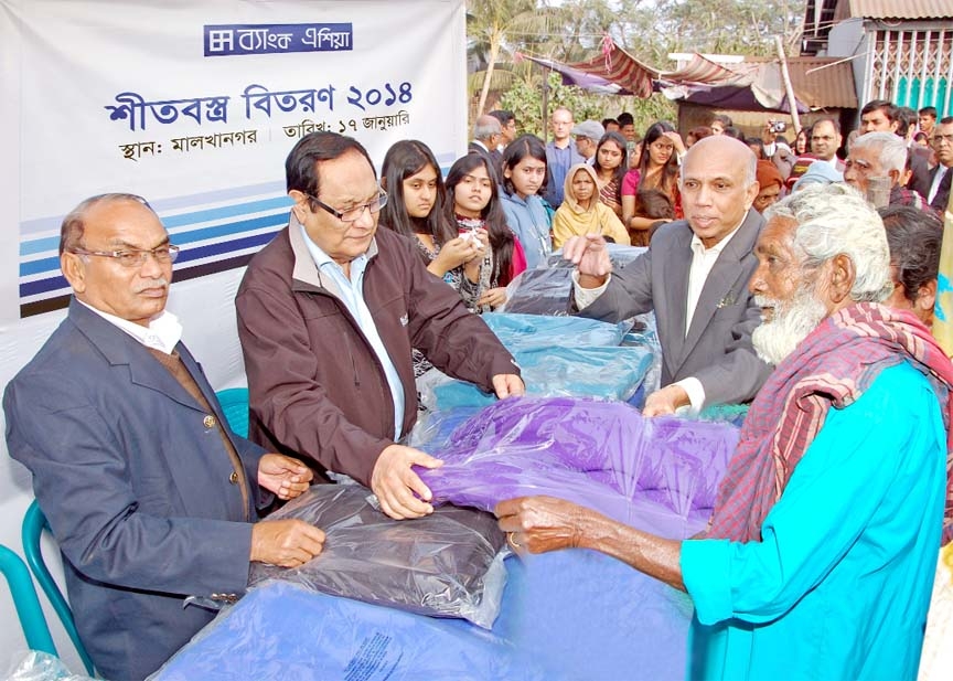 A Rouf Chowdhury, Chairman of Bank Asia Ltd, distributing blankets among the cold-hit poors of Malkhanagor under Sirajdikhan upazila of Munshiganj recently.