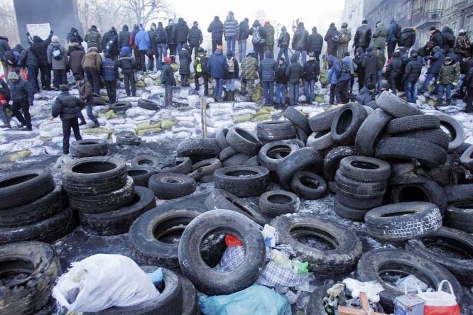 Protesters guard the barricade in front of riot police in Kiev, Ukraine on Friday.