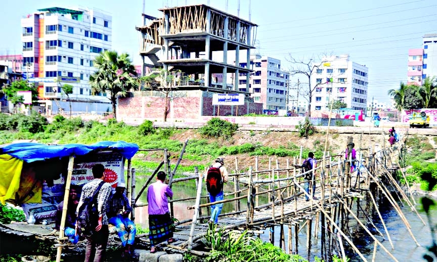 Agents of some influentials at Banasri area collecting tolls from the passers-by for crossing the bamboo bridge made earlier on the lake there, but without DCC permission. This photo was taken on Sunday.