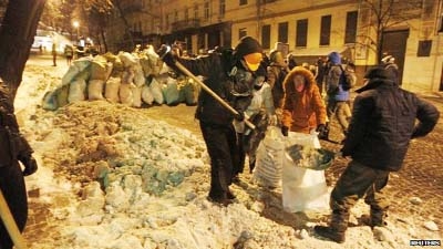 Ukraine activists fill up sacks with snow to build a barricade in front of the ministry of justice building.