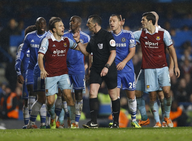 Chelsea's and West Ham's players question referee Neil Swarbrick during the English Premier League soccer match between Chelsea and West Ham United at Stamford Bridge Stadium in London on Wednesday.