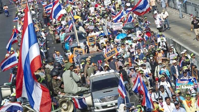 Thai anti-government protesters wave national flags during a rally in Bangkok.