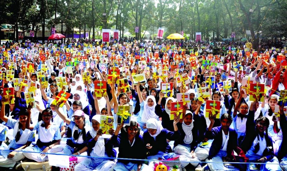 School students rejoicing after receiving books distributed by Biswa Sahitya Kendra at the Ramna Batomul on Friday.
