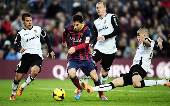 FC Barcelona's Lionel Messi (second left) duels the ball against Valencia's Juan Bernat (left) and Oriol Romeu (right) during a Spanish La Liga soccer match at the Camp Nou stadium in Barcelona, Spain on Saturday.