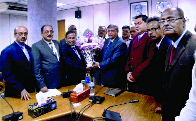 President of Bangladesh Specialized Textiles Mills and Power Loom Industries Association Azizul Haque along with others paying floral tributes to State Minister for Finance MA Mannan at the latter's Secretariat office in the city on Tuesday.