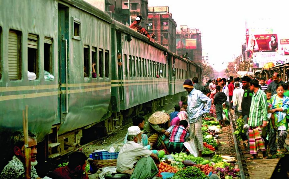 Kitchen market on railway track is a common feature in city now-a-days. Photo shows vendors selling vegetables risking their lives at Malibagh area on Thursday.
