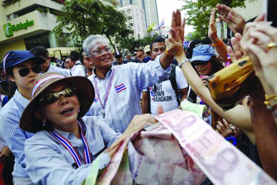 Protest leader Suthep Thaugsuban Â© greets anti-government protesters as he collect money they donate during the march in downtown Bangkok on Friday.