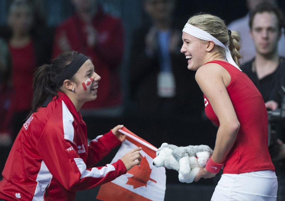 Canada's Eugenie Bouchard celebrates with teammate Sharon Fichman, left, after defeating Vesna Dolonc, of Serbia, during a Federation Cup tennis match in Montreal on Sunday.