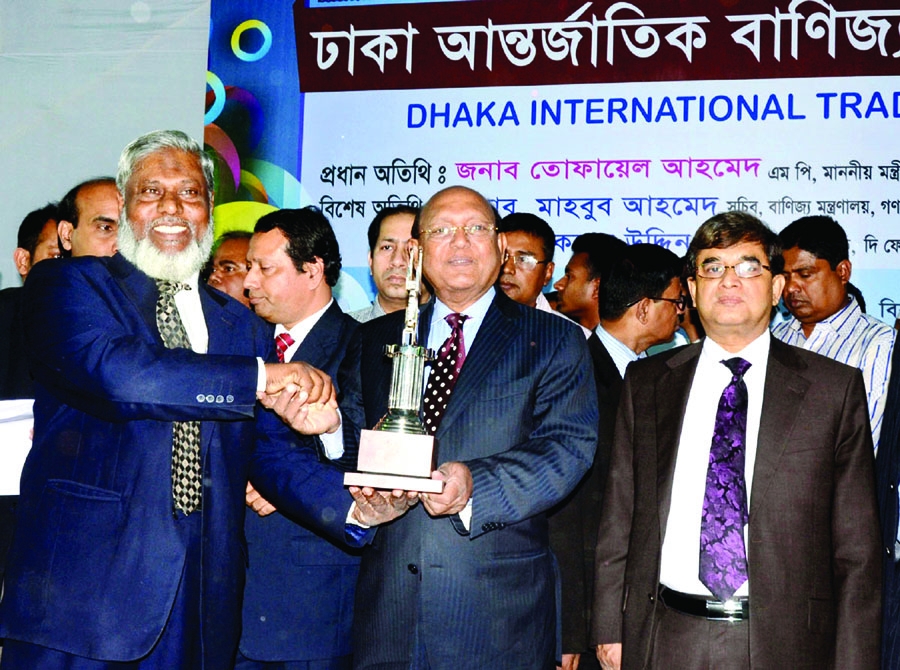 Tofail Ahmed, Minister for Commerce handing over the best pavilion prize at Dhaka International Trade Fair-2014 to AKM Abdul Malek Chowdhury, Deputy Managing Director of Islami Bank Bangladesh Limited at a ceremony on Monday. Mahbub Ahmed, Secretary, Comm