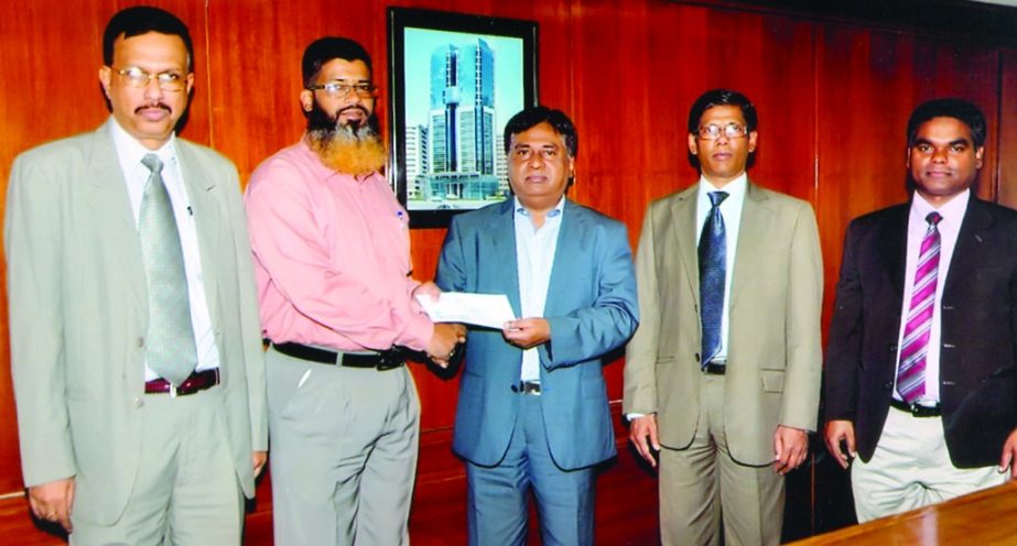 Chairman of the Central Insurance Company Ltd Md Shafi (3rd from right) handing over a cheque of Tk 10 lakh to Md Showkat Ali, borrower of Shahjalal Islami Bank Ltd, Karwanbazar branch and propritor of Palash Furniture Mart as settlement of fire insurance