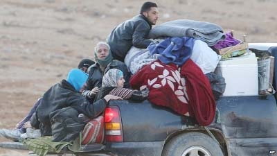 Syrians flee the town of Yabroud on the back of a truck. over the Lebanese border in anticipation of a major offensive.