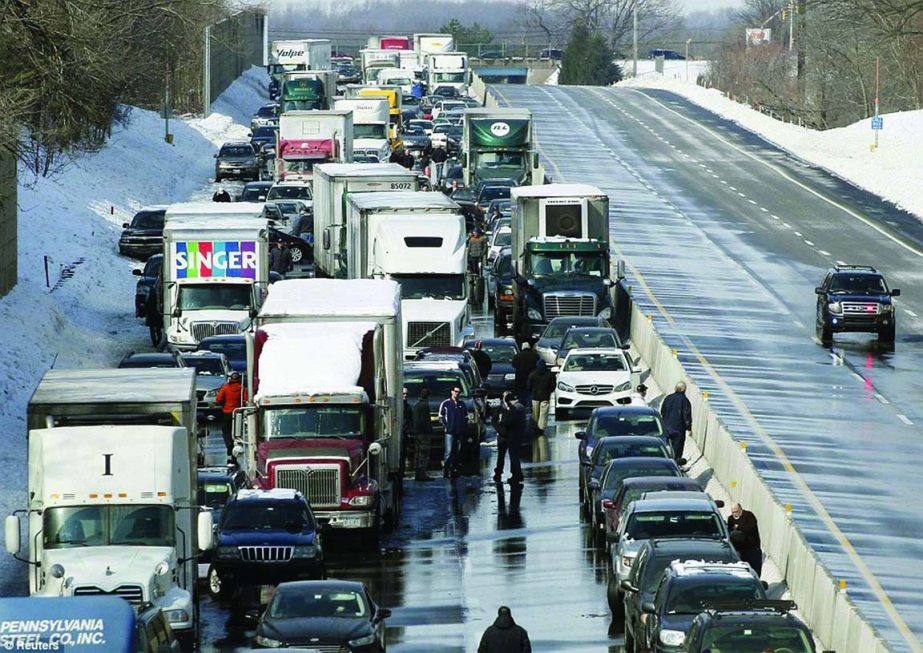 Drivers stand outside of their cars as traffic is backed up following a multi-car and truck accident near the Bensalem interchange in Pennsylvania, caused by bad weather on Friday.