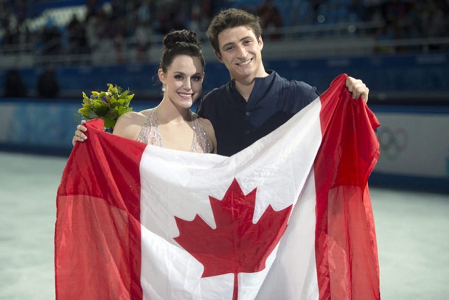Ice dance silver medallists Canada's Tessa Virtue (left) and Scott Moir pose with the Canadian flag during the flowers ceremony for the ice dance free dance figure skating finals at the 2014 Sochi Winter Olympics in Sochi on Monday.