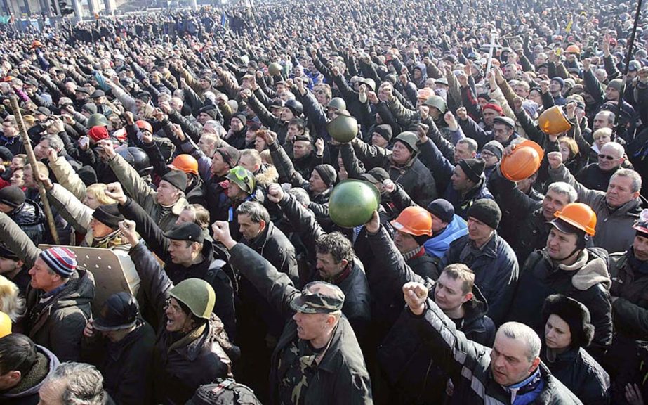 People cheer as they listen to police officers from Lviv who have joined anti-government protesters during a rally in Independence Square in Ukraine.