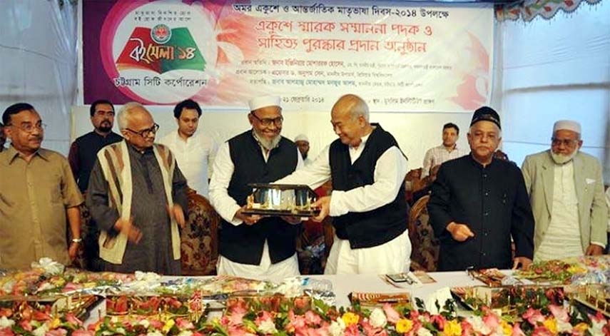 Minister for Housing and Public Works Engr Mosharaf Hossain handing over honourary awards at a function arranged on the occasion of International Mother Language Day at Muslim Hall premises on Friday.