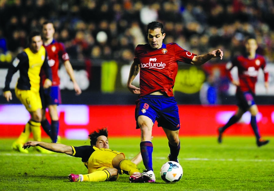 Atletico de Madrid's Koke (left) tries to controls the ball with Osasuna's Emiliano Armenteros of Argentina during their Spanish League soccer match, at El Sadar stadium in Pamplona, Spain on Sunday. Ateltico de Madrid lost the match 3-0.