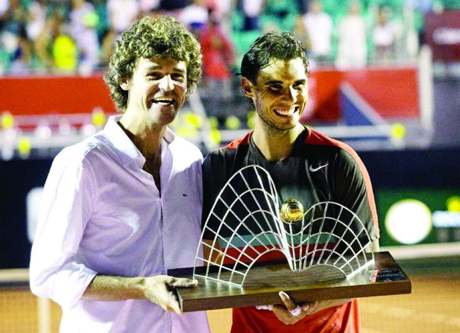 Spain's Rafael Nadal (right) and Brazil's former tennis player Gustavo Kuerten pose for a photo with Nadal's trophy at the end of the Rio Open tournament in Rio de Janeiro, Brazil on Sunday. Nadal returned from a troublesome back injury to win the Rio