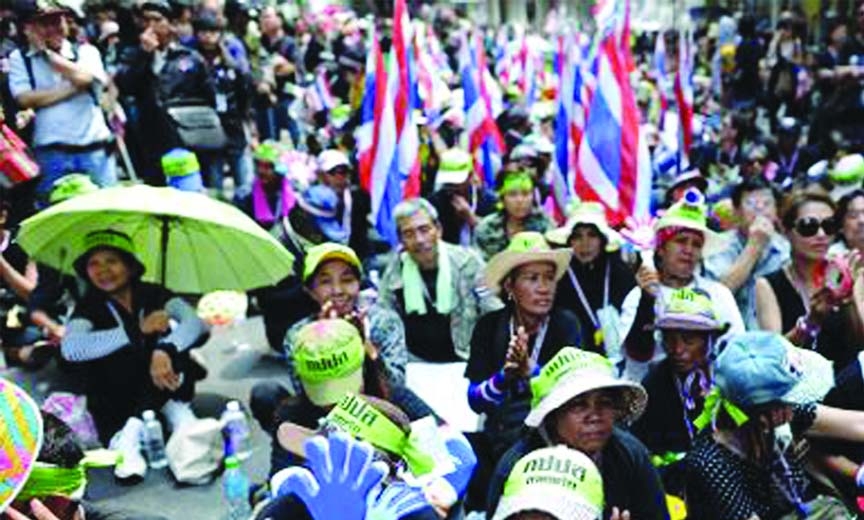 Thai anti-government protesters wave clappers as they rally outside the national police headquarters in downtown Bangkok on Wednesday.