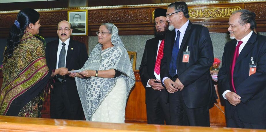 Prime Minister Sheikh Hasina handing over cheques of Tk 19.20 lakh on Tuesday to four families of the martyred army officers in the Pilkhana carnage. Prof. Abu Nasser Muhammad Abduz Zaher, chairman and Engr. Mustafa Anwar, vice chairman of the bank were