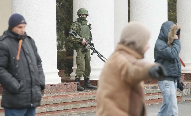 Soldiers, who were wearing no identifying insignia and declined to say whether they were Russian or Ukrainian, patrol outside the Simferopol International Airport as pro-Russian men wearing the Ribbon of St. George, a symbol of Russiam military valour, di