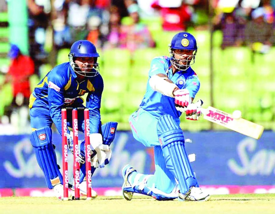 Indian cricketer Shikhar Dhawan (R) plays a shot as Sri Lankan wicketkeeper Kumar Sangakkara (L) looks on during the fourth match of the Asia Cup one-day cricket tournament between India and Sri Lanka at the Khan Shaheb Osman Ali Stadium in Fatullah on Fr