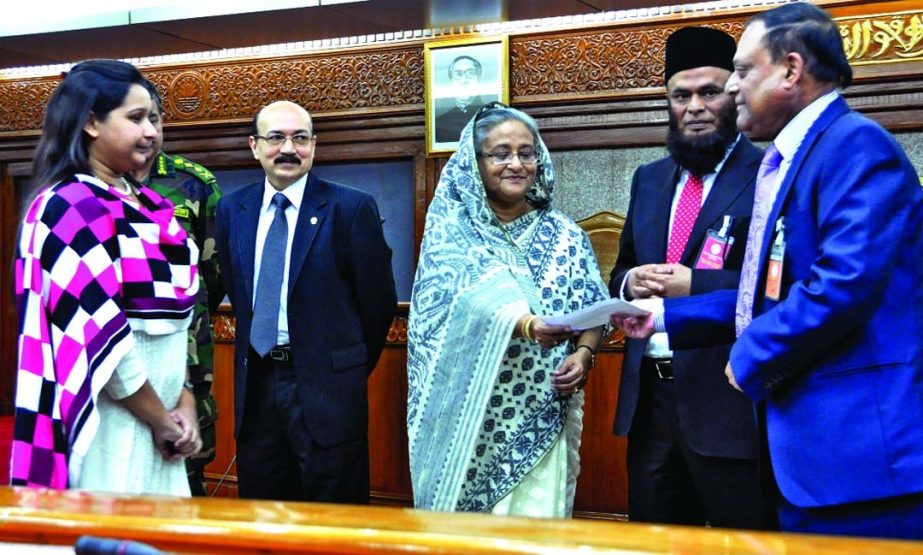Prime Minister Sheikh Hasina handing over a cheque of Tk 4.80 lakh to martyred army officers families at Ganobhaban recently. Vice-Chairman of the Board of Directors of Pubali Bank Ltd. Habibur Rahman handed over the cheque to Sheikh Hasina as part of the