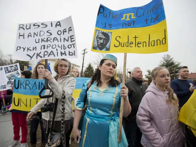 Velida Kent, second from right, whose family originated from Crimea, wears her native Crimean Tatar outfit, during a protest rally in front of the Russian embassy, in Washington on Sunday.