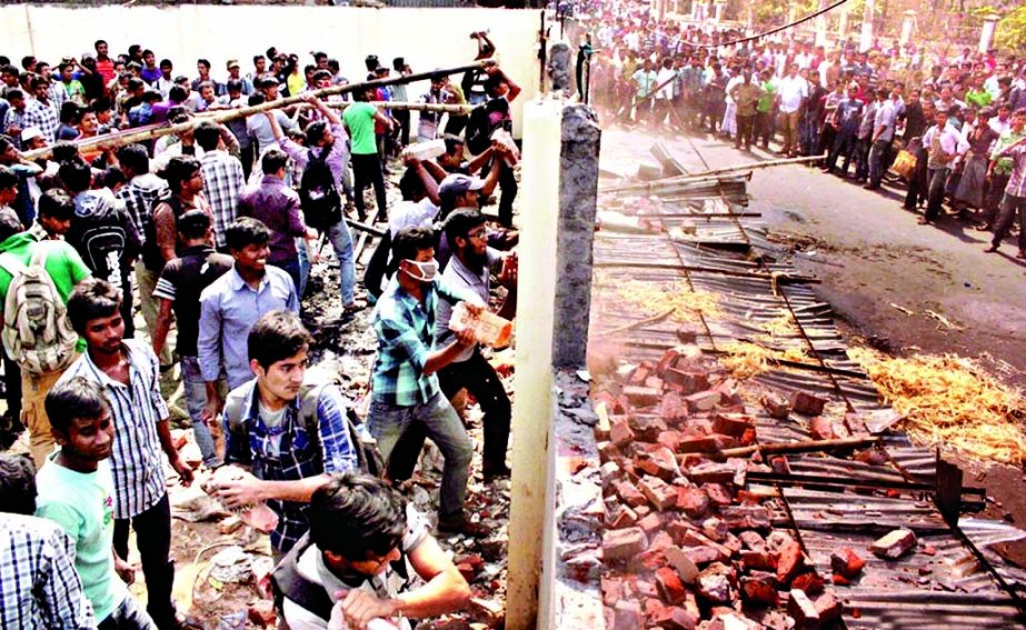 The agitating students of JnU on Tuesday demolished the wall of Bangladesh Bank branch near Victoria Park in a bid to occupy a vacant portion of the land inside the bank originally owned by JnU.