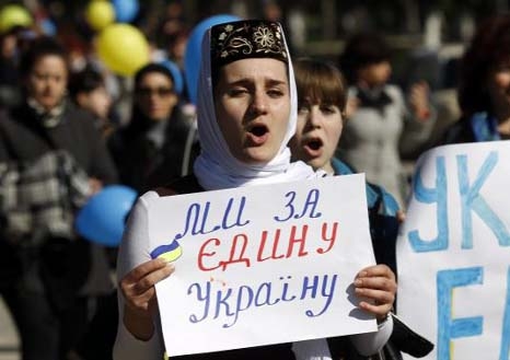 Participants hold placards and shout slogans during an anti-war rally in the Crimean town of Bakhchisaray.