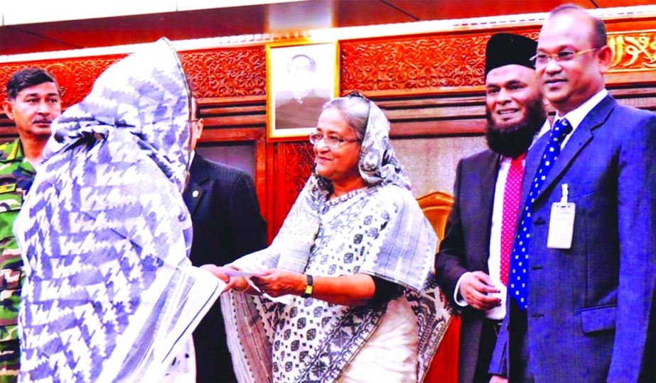 Prime Minister Sheikh Hasina handing over a cheque of Tk 4.80 lakh to the family of army officer Col Md Rezaul Kabir, killed in BDR carnage at Pilkhana, in a program at Gonobhaban recently. Al-Arafah Islami Bank provided the money as Corporate Social Resp