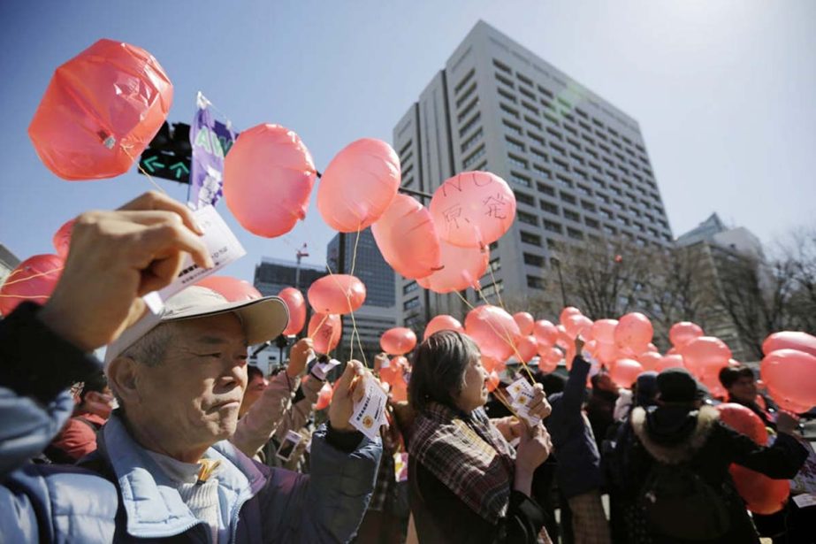Anti-nuclear protesters prepare to release balloons during a rally in front of the Ministry of Economy, Trade and Industry (METI) in Tokyo on Tuesday.