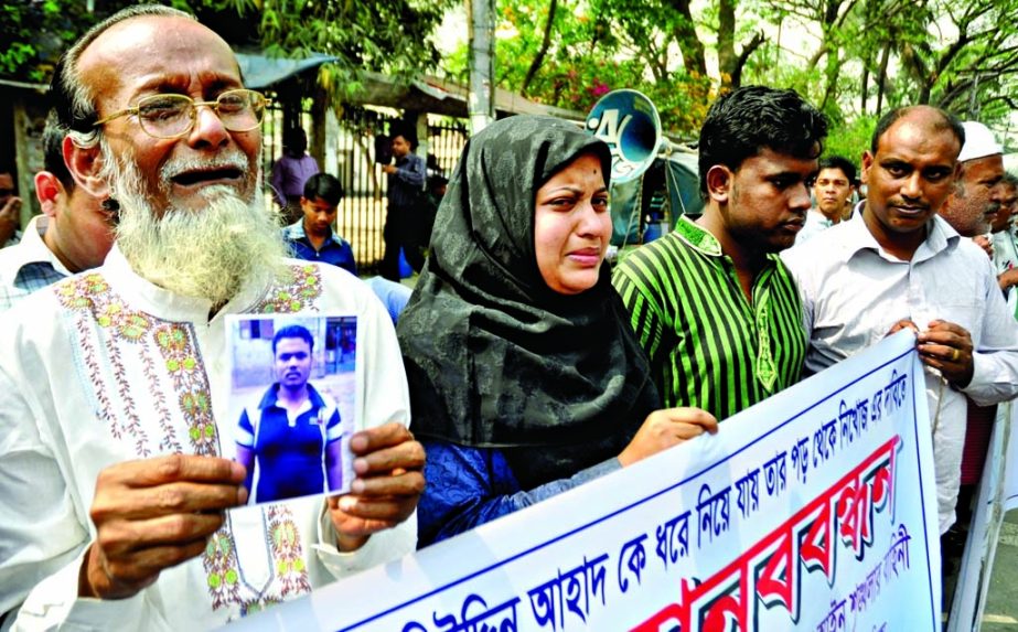 Family members of Mohiuddin Ahad who was picked up recently from Muktijoddha Complex at city's Chiriakhana Road pleading to RAB, formed human chain in front of Jatiya Press Club on Wednesday for release of son.