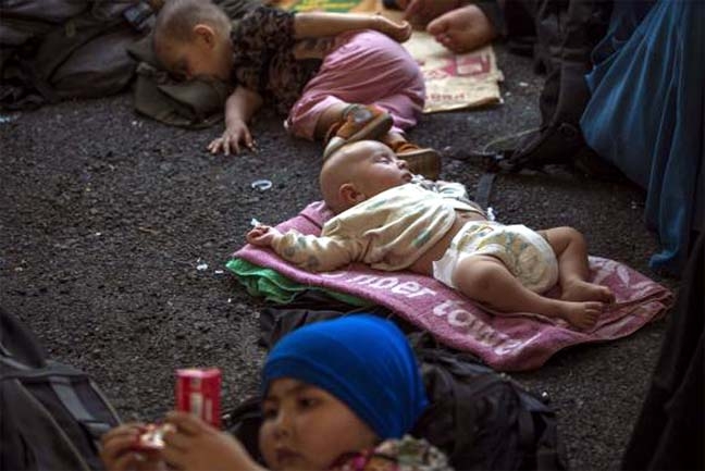 Children of suspected Uighurs from China's troubled far-western region of Xinjiang, rest on a ground inside a temporary shelter after they were detained at the immigration regional headquarters near the Thailand-Malaysia border in Hat Yai, Songkla on Fri