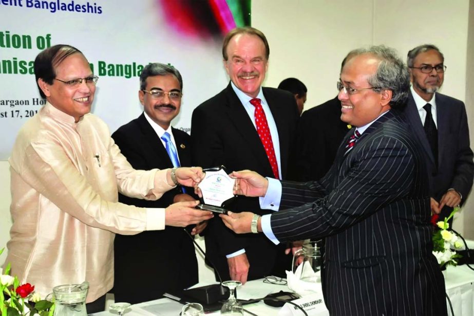 Bangladesh Bank Governor Dr Atiur Rahman handing over Silver Medal to Mohammad Shams-Ul Islam DMD of Agrani Bank for bringing remarkable remittance on the eve of World Conference Series 2014 NRB Centre held at a city hotel recently. US Ambassador Dan W Mo