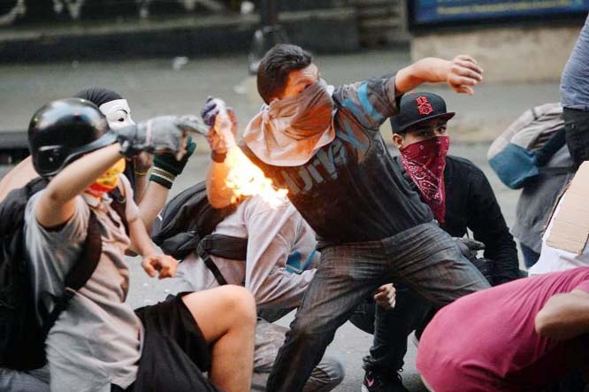 Demonstrators clash with members of the national guard during a protest against Venezuelan President Nicolas Maduro, in Caracas, on Sunday.