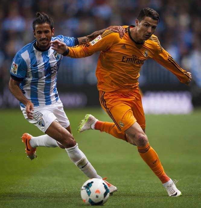 Real Madrid's Cristiano Ronaldo (right) duels for the ball against CF Malaga's Marcos Alberto Angeleri (left) during a Spanish La Liga soccer match at La Rosaleda stadium in Malaga, Spain on Saturday.