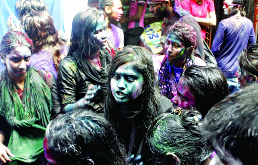 People of Hindu community anoint colour powder with one another marking Holi festival. The snap was taken from the city's Shankhari Bazar area on Monday.