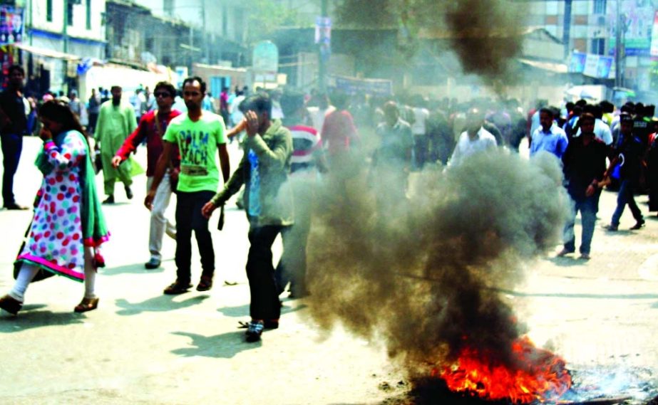 Students of Jagannath University agitating by setting fire on a busy road in the city on Tuesday reiterating demands for recovery of their dormitories from the illegal occupation.