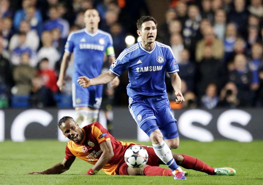 Chelsea's Frank Lampard (right) takes the ball away from Galatasaray's Didier Drogba who lies on the ground during the Champions League last 16 second leg soccer match between Chelsea and Galatasaray at Stamford Bridge stadium in London on Tuesday.