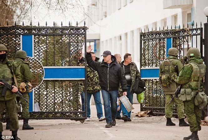 Waving goodbye: Ukrainian servicemen leave a Ukrainian military unit after it was taken over by Russian forces in Sevastopol, Crimea, on Wednesday.