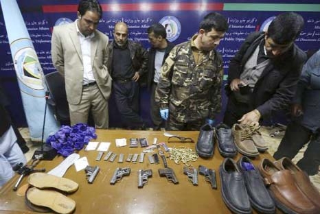 Afghan security officials display the weapons and bullets of Taliban insurgents that were killed last night in a luxury hotel in Kabul on Friday.
