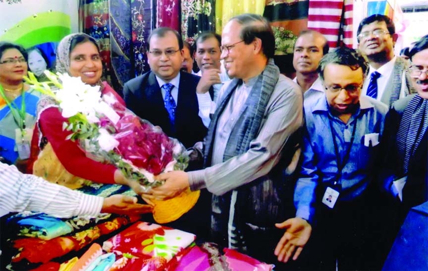 Bangladesh Bank Governor Dr Atiur Rahman visiting Bangladesh Krishi Bank stall at "Women Entrepreneurs and Product Display 2014" at a city hotel recently. Sultana Kabir, proprietor of 'Sultana Embroidery' greets the chief guest with bouquet at the st